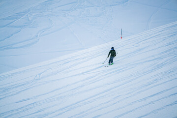 young woman skiing in the middle of the mountain. various trails in the snow of other skiers