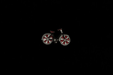 enameled metal brooch bicycle icon on a black background