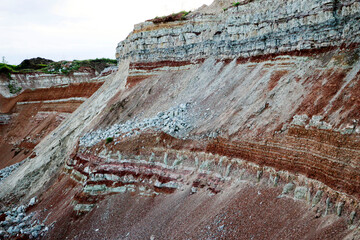 textures of various clay layers underground in  clay quarry after  geological study of  soil. colored layers of clay and stone in  section of  earth, different rock formations and soil layers.