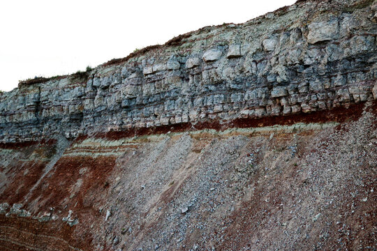 textures of various clay layers underground in  clay quarry after  geological study of  soil. colored layers of clay and stone in  section of  earth, different rock formations and soil layers.