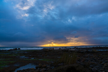 Fototapeta premium A sunset over the sea, with bad weather and rain