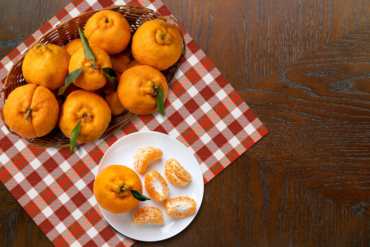 Ponkan tangerines in a fruit bowl on the table. Mandarin ponkan peeled in a plate in buds.