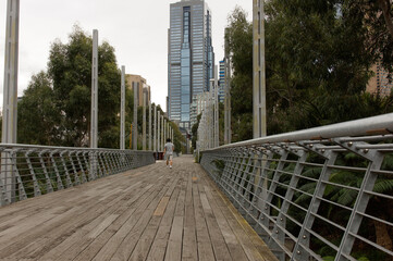 Man walking on wooden plank foot-bridge to Melbourne CBD