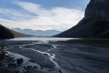 lake louise and fairmont hotel with low water level and sandy shore at the foreground