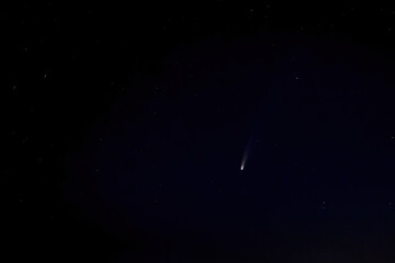 C / 2020 F3 comet (NEOWISE) in the night sky between the bright stars. Space view from the countryside. Unusual space phenomena