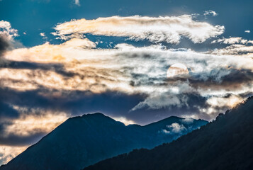 Fototapeta premium Silhouette of mountain range at orange cloudy sunset