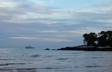 View of dawn at the seaside with the dramatic sky, boat and mountain, Tioman Island