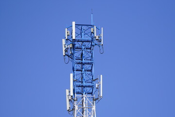 Small Cell 3G, 4G, 5G System. Macro Base Station or Base Transceiver Station. Wireless Communication Antenna Transmitter  tower against blue sky background.