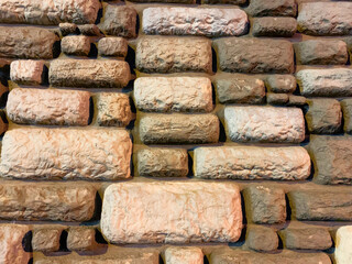 Brick wall. Bricks of different sizes in warm brown shades.