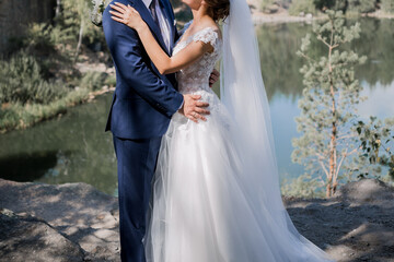 Fototapeta na wymiar the groom with bride on the stones near the lake