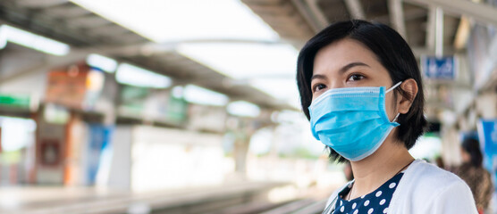 Fototapeta na wymiar Young Asian woman wearing blue protective face mask, Banner. 