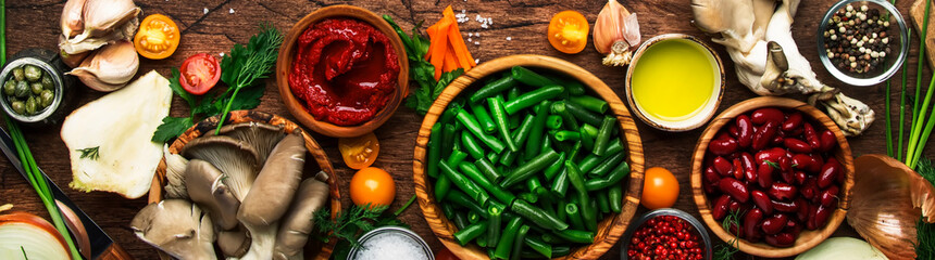 Food cooking background, ingredients for preparation vegan dishes, green bean, vegetables, roots, spices, mushrooms and herbs. Panoramic banner with copy space