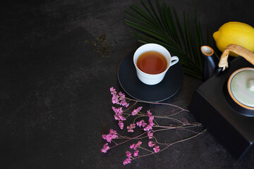 Obraz na płótnie Canvas Tea in a white cup with teapot on a dark table