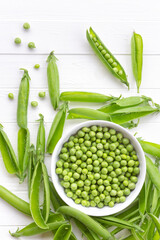 Green peas on a white table. Fresh harvest from the garden. Shelled and husked green peas,...