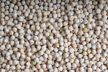 Background texture made of uncooked raw brown chickpeas. Image with horizontal orientation