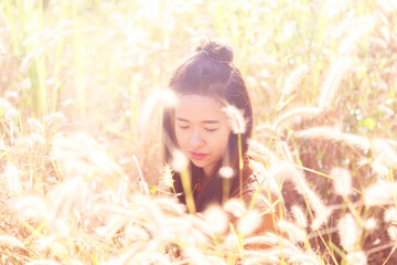 Fototapeta premium Romantic girl standing on the mountain in the flowers grass field at Thong Pha Phoom national park ,Kanchanaburi province ,Thailand.