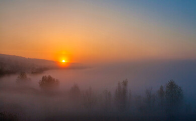 Beautiful foggy autumn sunrise landscape.