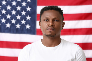 Sad African-American man near national flag of USA. Stop racism