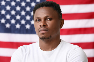 Sad African-American man near national flag of USA. Stop racism