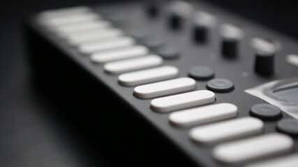 Professional dj midi controller device in close up video clip.White button keys on digital musical instrument in sound recording studio.Edm & techno music producer equipment for live set on party