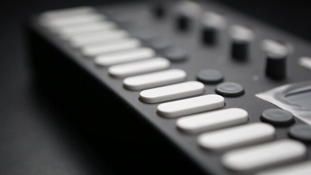 Professional dj midi controller device in close up video clip.White button keys on digital musical instrument in sound recording studio.Edm & techno music producer equipment for live set on party