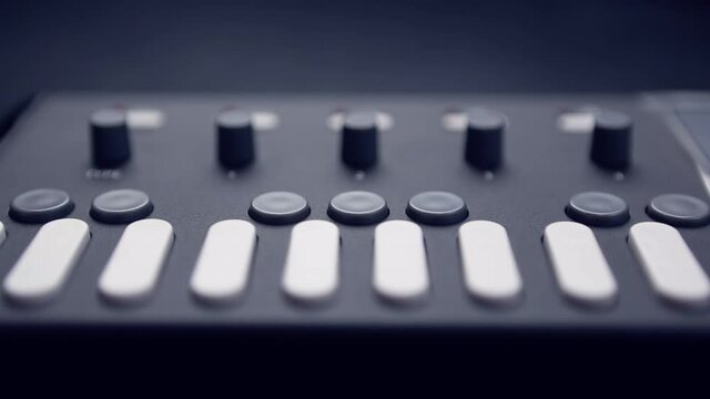 Professional dj midi controller with push button keys in closeup video clip.Modern disc jockey audio equipment for electronic music production.Zooming in footage of musical instrument for edm producer