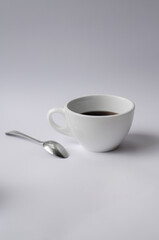 cup of coffee with spoon and white minimal background