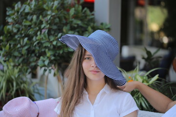 two girls are sitting in a cafe drinking coffee and taking selfies