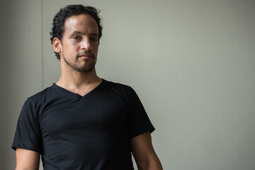 Portrait of handsome bearded Hispanic man indoors