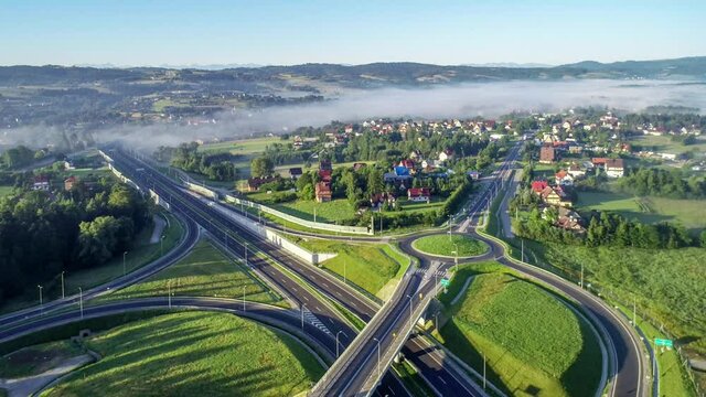 New motorway junction in Poland on national road no 7, E77, called Zakopianka.  Overpass crossroad with traffic circles, viaducts  and slip roads near Rabka. Aerial video. Far view of Tatra Mountains