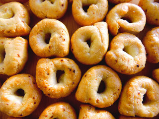 Taralli or tarallini - italian bagel pretzel regional apulia & puglia food. Taralli - traditional Italian food typical of Apulia regional cuisine, top view background. Salted bread sticks snack