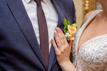 bride adjusts buttonhole to her groom