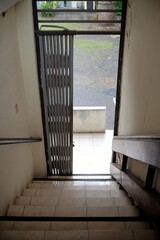 The stairs descend to the door that will soon be closed