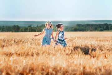 Happy teenage girls running down wheat field