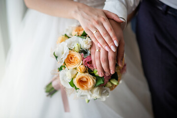 Obraz na płótnie Canvas wedding rings on the hands of the newlyweds