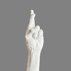 Hand is painted roughly white. Hand gesture isolated on gray background. Bold body art painting.