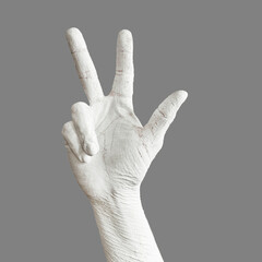 Hand is painted roughly white. Hand gesture isolated on gray background. Bold body art painting.