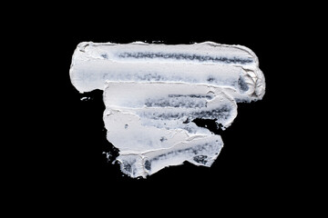 Brushstroke with a thick white paint, isolated on a black background.