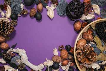 elegant dried botanical mixture and bamboo bowl on a purple background creating a frame shape with copy space