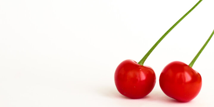 Heart shaped two cherry berries isolated on white background. cherries isolated on white background clipping path. closeup red summer fresh healthy fruit. photo for banner or for design