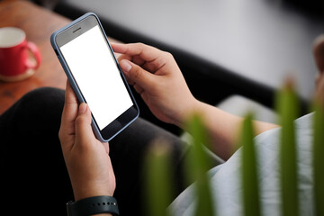 Cropped shot view of man hands holding smart phone with blank copy space screen for your text message or information content, female reading text message on cell telephone during in urban setting. 
