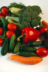 Fresh vegetables on a white background. Broccoli, zucchini, tomatoes, cucumbers, carrots, peppers, dill. Healthy organic food for vegetarians. Ingredients for summer salad.