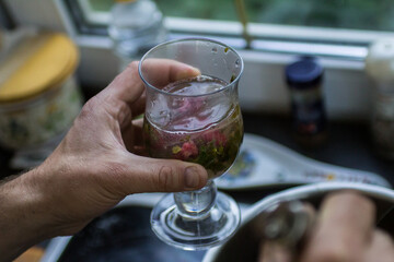refreshing cocktail with mint, lemon, lime and raspberries in the guest's hands