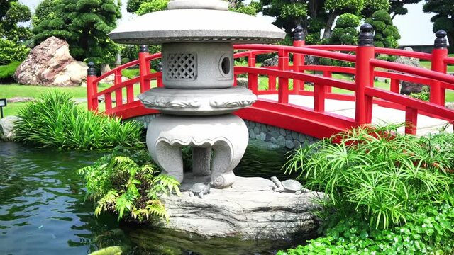 Cypresses emerge to stone bridge garden architecture in Vietnam with rockery stone, bonsai cypress, pine perpetual, below the swimming pool Koi fishes streams have very beautiful as paintings incorpor