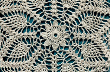Beautiful closeup crochet doily on blue wooden background