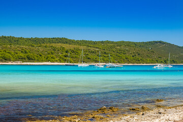 Azure turquoise lagoon on Sakarun beach on Dugi Otok island, Croatia, yachts anchored in clear sea water.