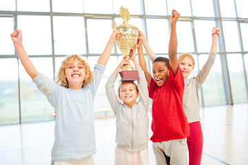 Fototapeta premium Successful children team with cup cheers