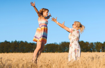 woman jumping to mother in field