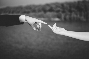 Two hands stretch to each other. Black and white photography. The photograph resembles the fresco...