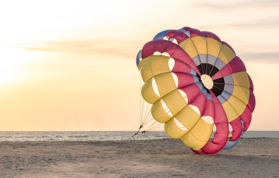 Beautiful photo of colorful parasailing parachute anchored on secluded beach for tourists loving adventure sports. Photo is well isolated. Concept of Growth, Independence, Resistance, lockdown etc.